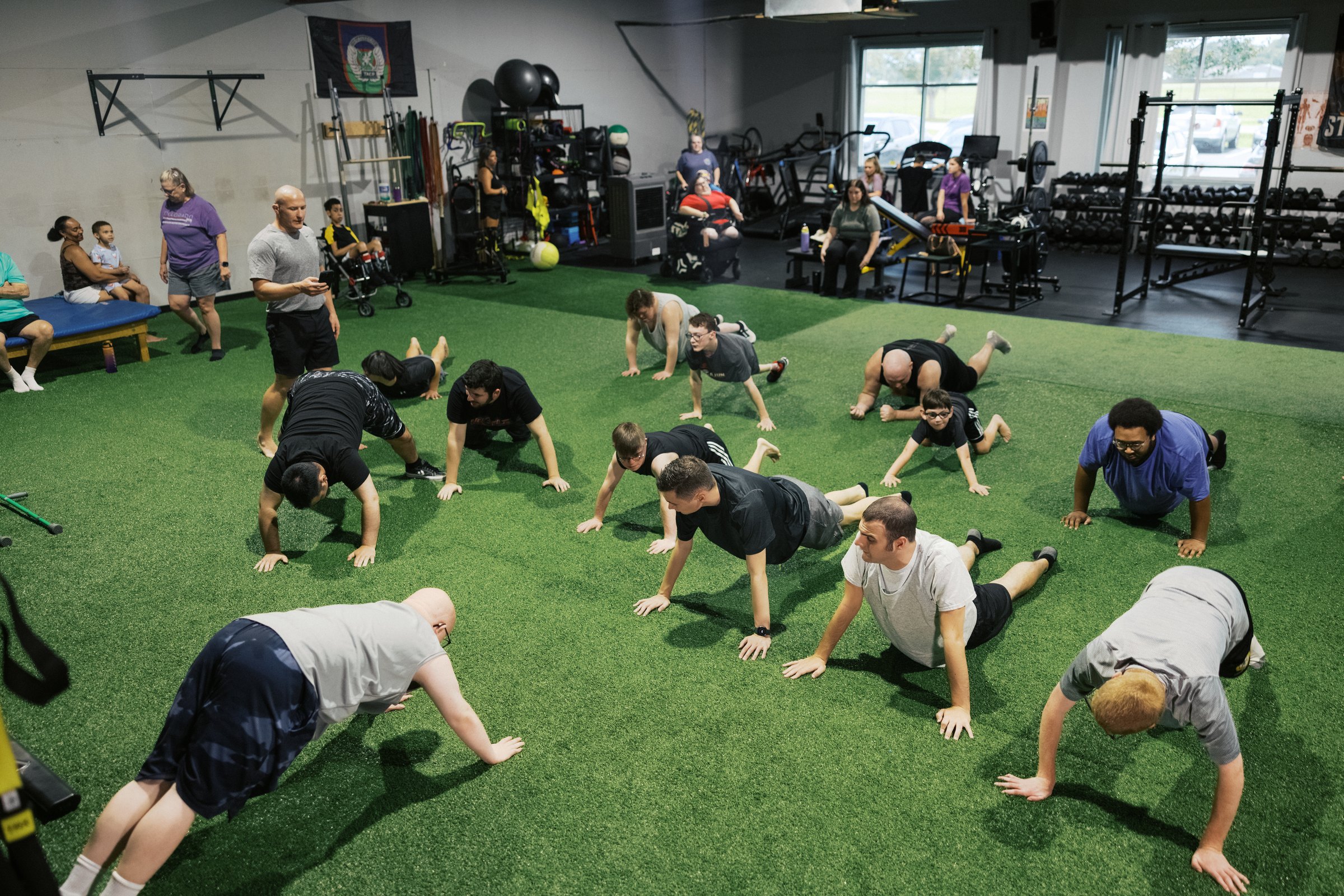 A group of athletes doing push-ups together on the turf